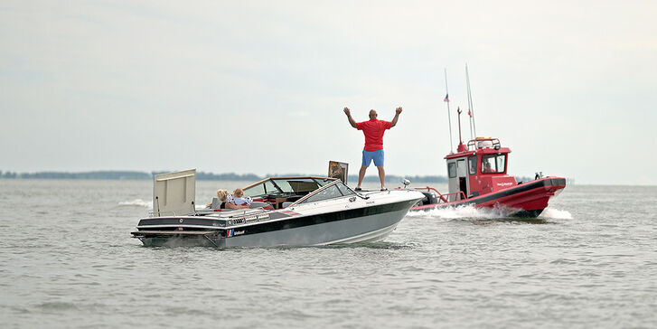person on a boat flagging down a boat us tow boat