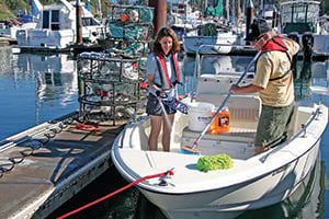 two people using a deckbrush and a hose to clean the deck