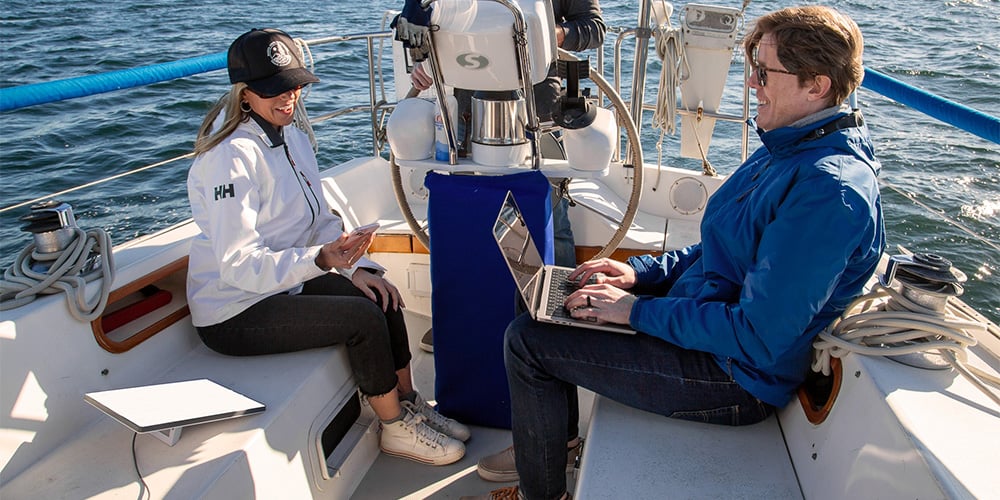 2 people using Starlink on a boat