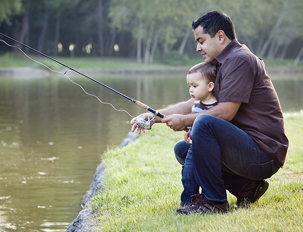 Father fishing with toddler boy