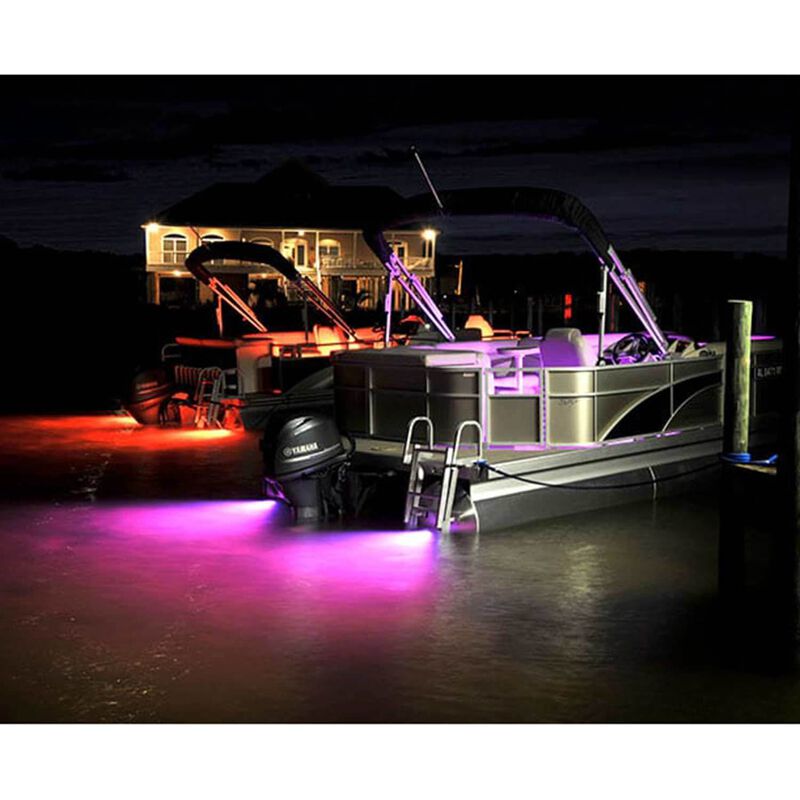 Boats at dock at nights with underwater ligthts illuminating water