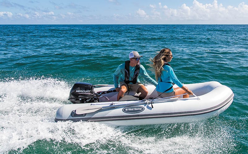 *Man and woman planing across the water in an inflatable boat