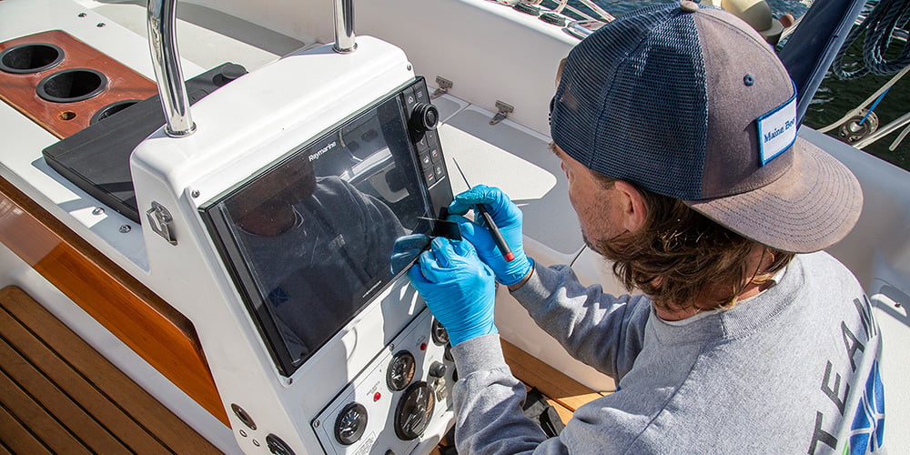 person installing marine electronics on a boat