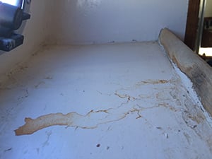 brown stains on a shelf indicating damage to plywood deck overhead