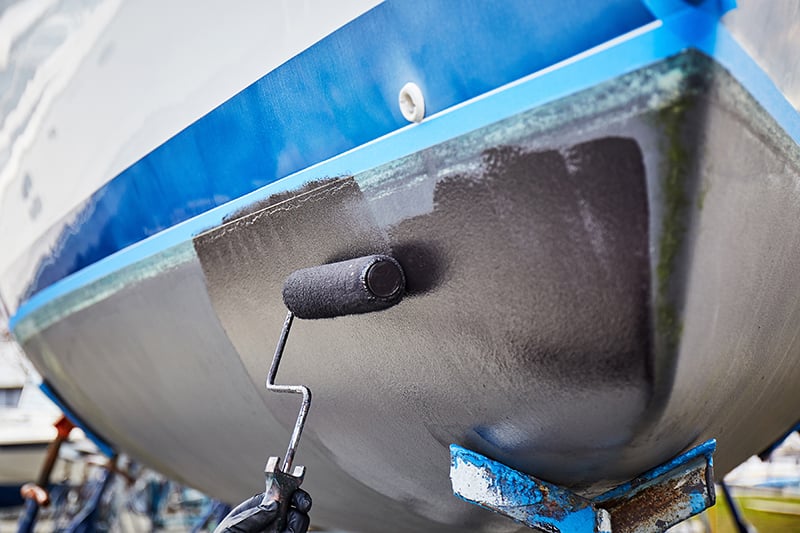 Image of roller applying bottom paint to bow of sailboat