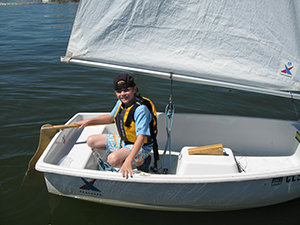 kid on an optimist pram dinghy