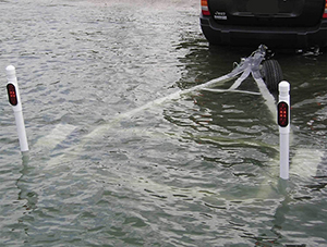 Submerged trailer at launch ramp with guide posts showing above water