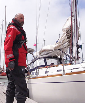 Sailor in foul weather gear with Sailboat