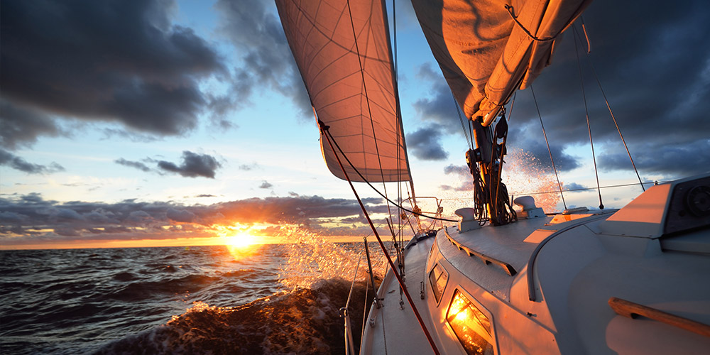 Sailboat sailing toward sunset