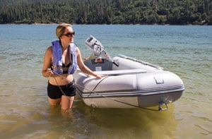 person guiding an inflatable boat through shallow water