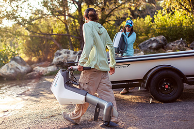 Man Carrying Electric Outboard Motor