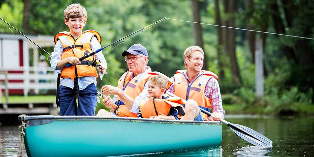 Two young boys, their father and grandfather in small canoe fishing
