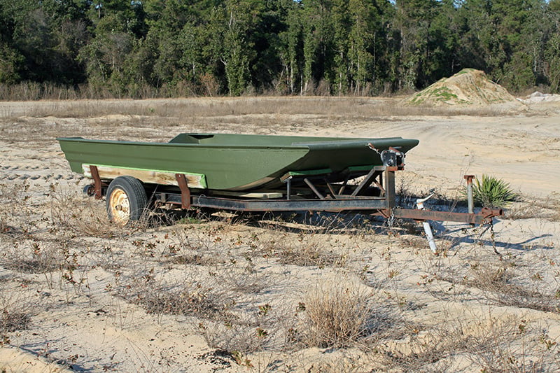 *Green Jon boat on trailer in field