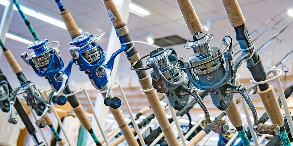 Spinning rod and reel combos displayed on a retail rack at West Marine