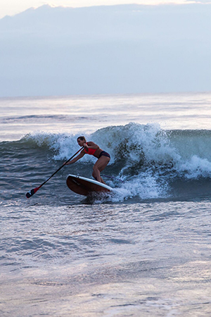 Author Seychelle making a bottom turn when surfing a wave