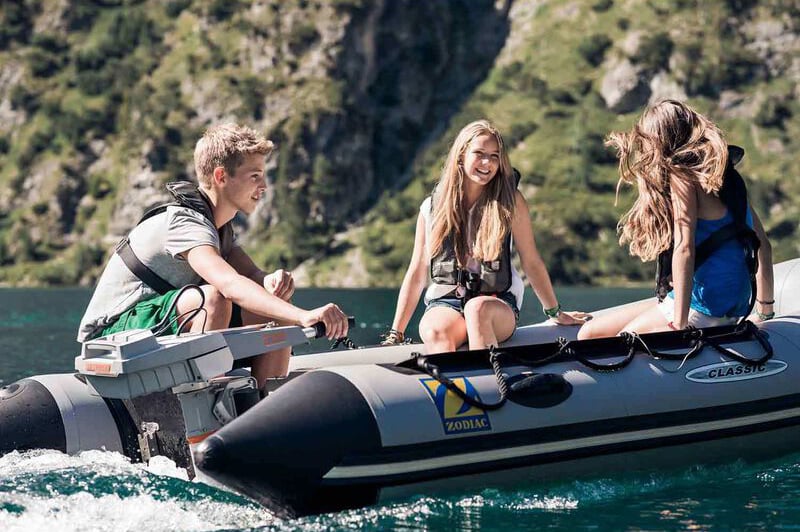 young people in inflatable boat powered by electric outboard