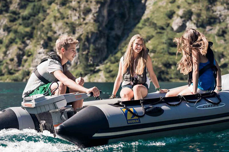 young people in inflatable boat powered by electric outboard